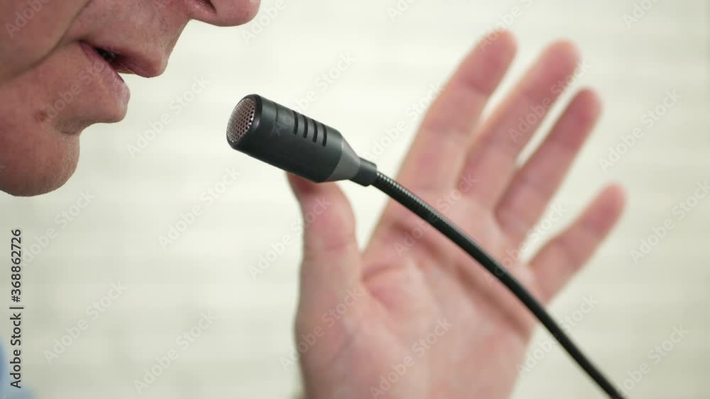 Blurred Image of a Businessman Speaker in a Press Conference Talking at the Microphone Blurred Image of a Businessman Speaker in a Press Conference Talking at the Microphone