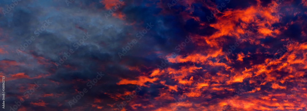 Sky is like a conflagration, majestic atmosphere. Blazing sky, dramatic sunset. Clouds at sunset illuminated by the sun from below, panoramic view