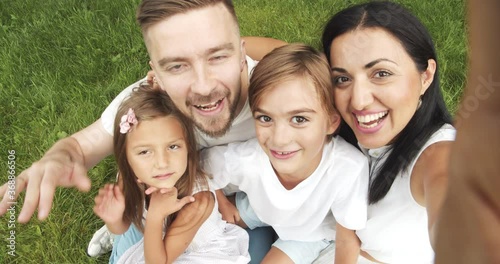Happy family taking selfie or recording video on a digital camera during summer vacation. Weekend and travel concept.