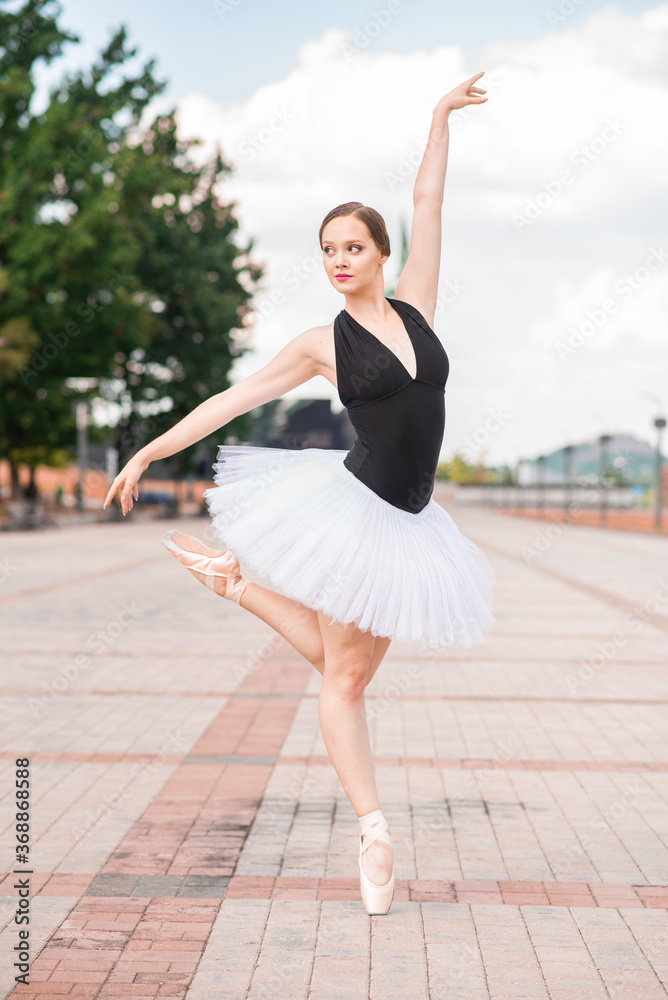 Young and beautiful ballerina posing on the street