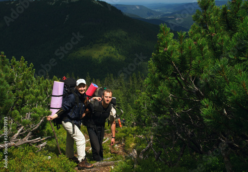 Young male and female tourists on a walk in the mountains 