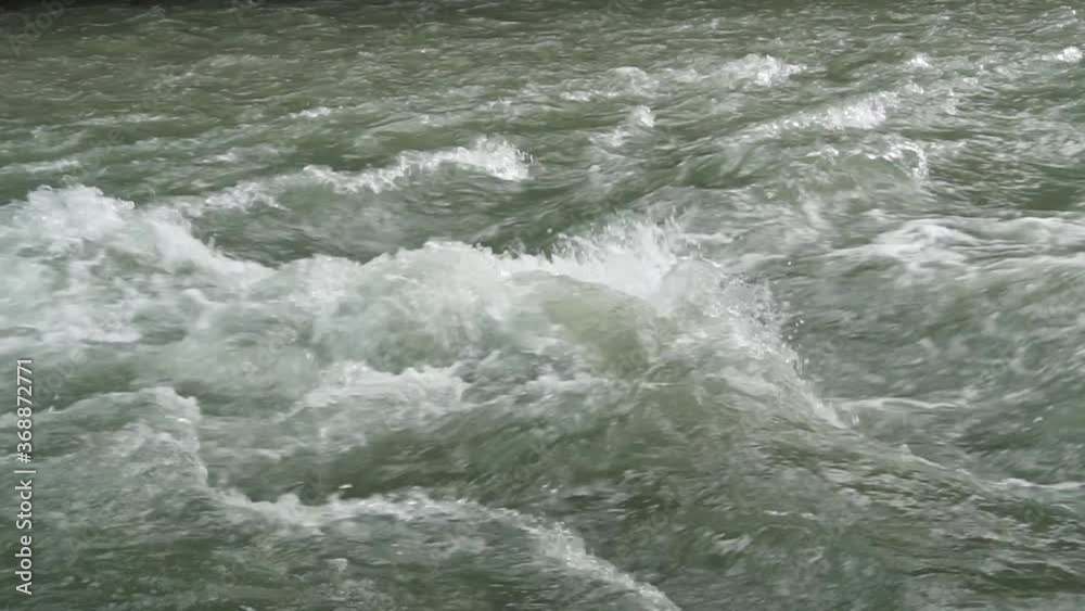 Rapid flow of water from a mountain river is rushing rushing and foaming over. Water surface for background. B-roll slow motion footage Rapid flow of water from a mountain river is rushing rushing and foaming over. Water surface for background. B-roll slow motion footage