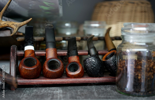 a collection of old briar pipes for smoking on a stand