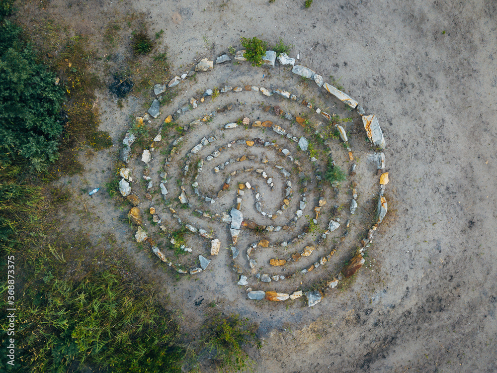 Spiral labyrinth made of stones, top view from drone