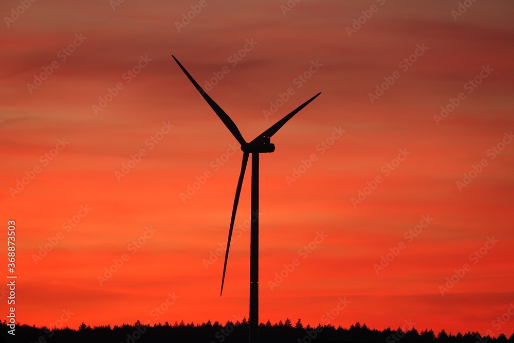 Windrad am roten Abendhimmel im Schatten