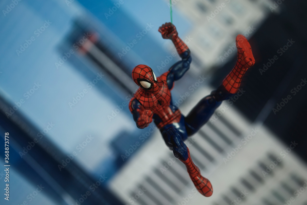 Obraz premium NEW YORK USA - AUGUST 2 2020: Scene with Marvel comic superhero Spiderman swinging from a web - Hasbro Marvel Legends figure