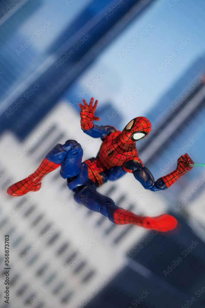 Obraz premium NEW YORK USA - AUGUST 2 2020: Scene with Marvel comic superhero Spiderman swinging from a web - Hasbro Marvel Legends figure