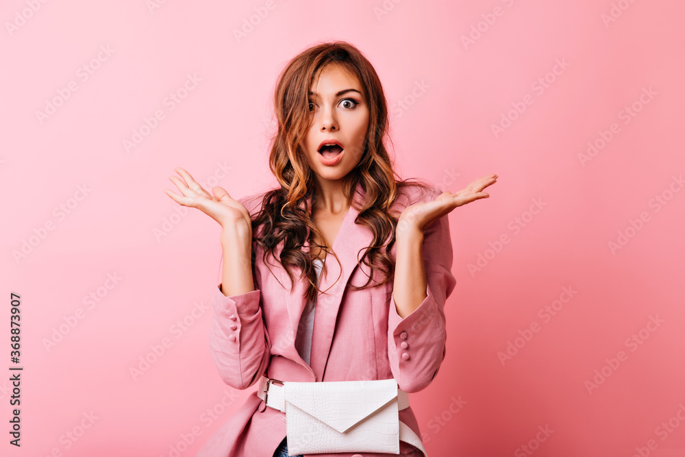 Shocked red-haired girl in pink jacket waving her hands. Studio photo of amazed fashionable woman isolated on pastel background. Shocked red-haired girl in pink jacket waving her hands. Studio photo of amazed fashionable woman isolated on pastel background.