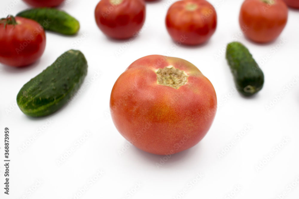 Fresh tomatoes and cucumrers on a white background, flat lay. Healthy food, vegan food. Fresh tomatoes and cucumrers on a white background, flat lay. Healthy food, vegan food.