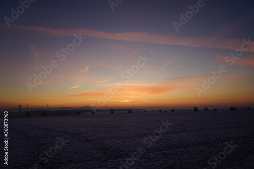 Winterlandschaft mit Frost und Schnee nach Sonnenuntergang im Nebel