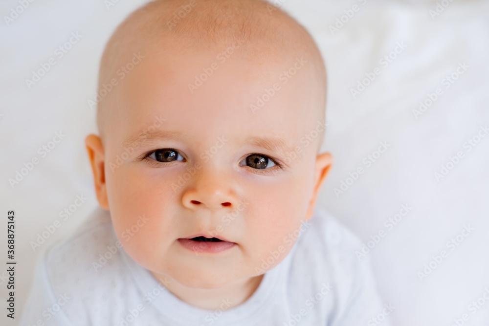 Portrait of a cute baby boy in cotton white after. textiles for the child, hypoallergenic materials.