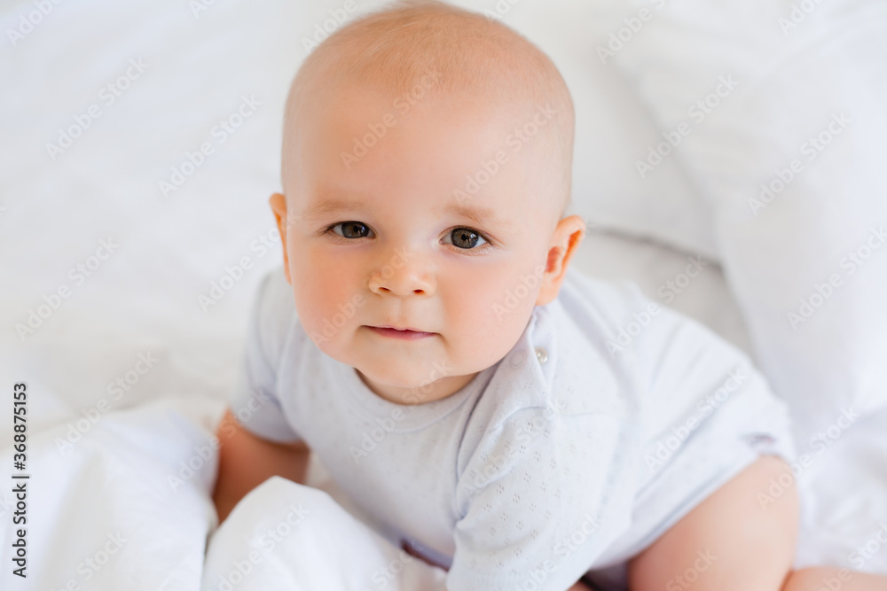 Portrait of a cute baby boy in cotton white after. textiles for the child, hypoallergenic materials.
