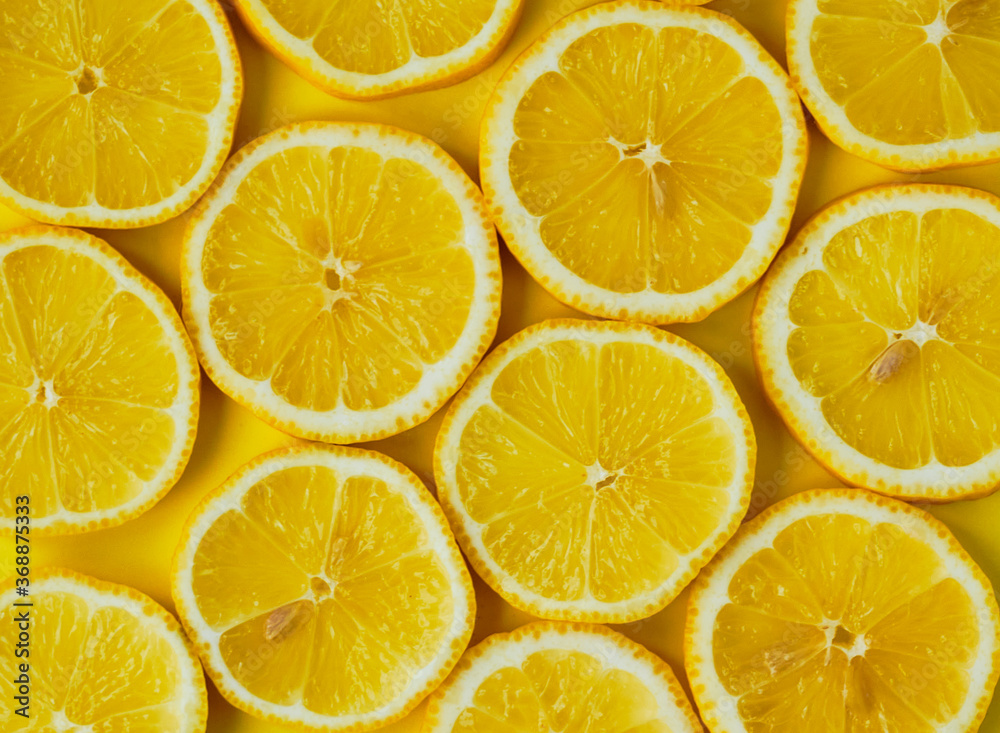 Sliced lemons in round slices on yellow background. Sliced lemons in round slices on yellow background.