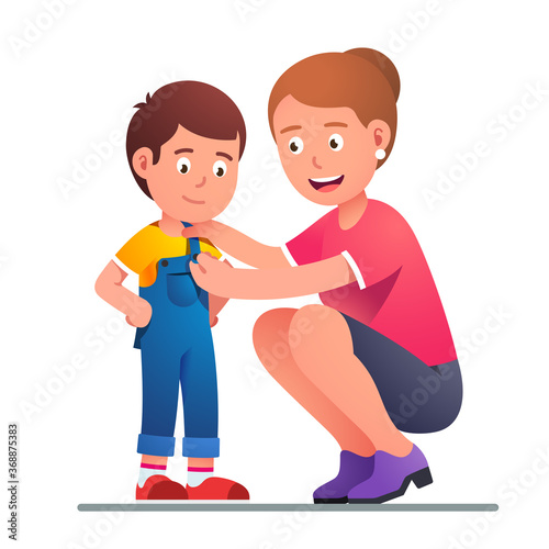 Mother helping boy son to dress up