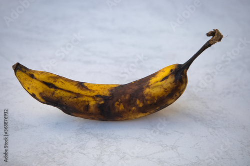 close up of an old brown overripe banana on a bright underground