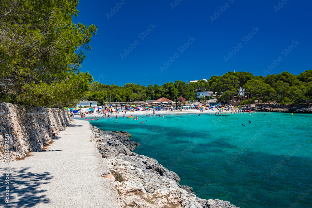 Fototapeta premium CALA MONDRAGO, Majorka, Spain, 24 July 2020 - People enjoy the beach in summer, Parque Natural de Mondrago. Santanyi. Malorca. Spain