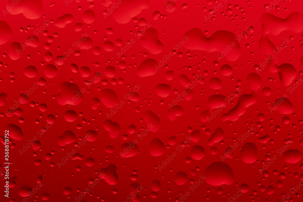 Water drops of different sizes on a red background Water drops of different sizes on a red background