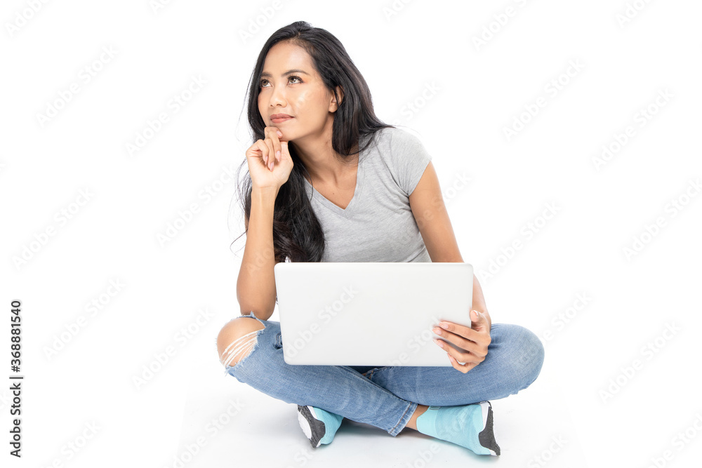 Isolated Asian woman sits on the floor using a Laptop. Isolated Asian woman sits on the floor using a Laptop.