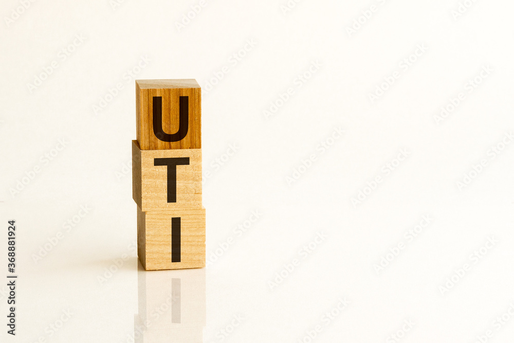 Word UTI - Urinary Tract Infection - on a wooden cubes on a white background Word UTI - Urinary Tract Infection - on a wooden cubes on a white background