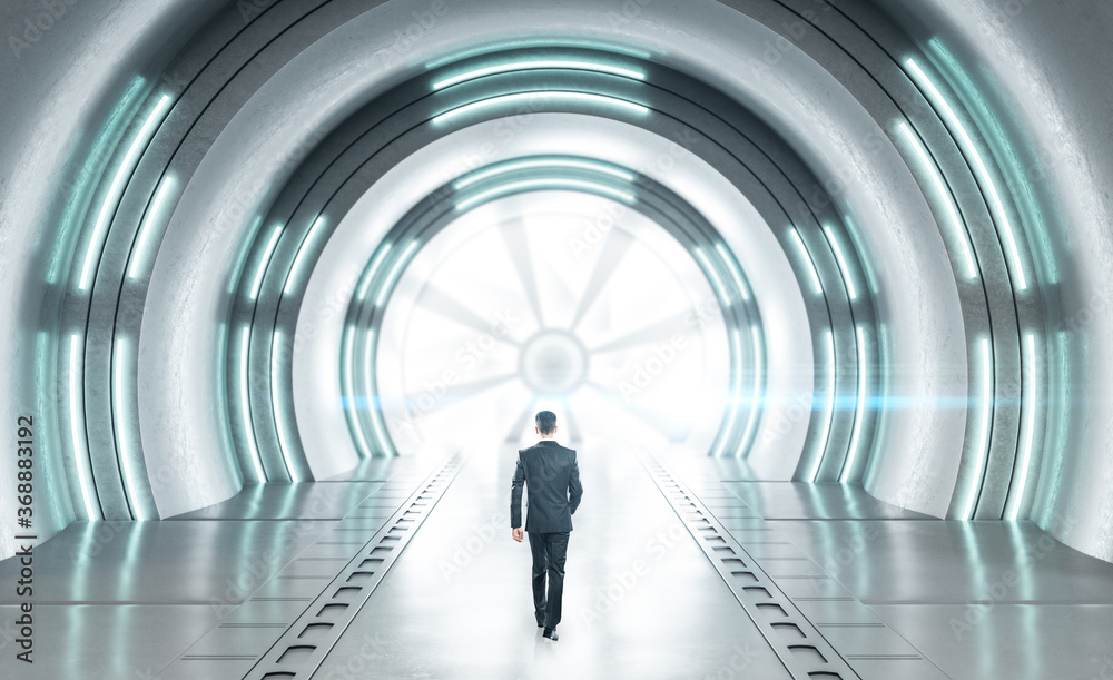 Fototapeta premium Businessman walking in futuristic concrete space ship interior