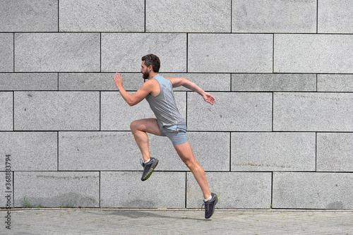 male runner. man running to success. sport success. Striving for victory. active man in sport clothing jumping while exercising outdoors. guy sprinting on the street. Leap forward