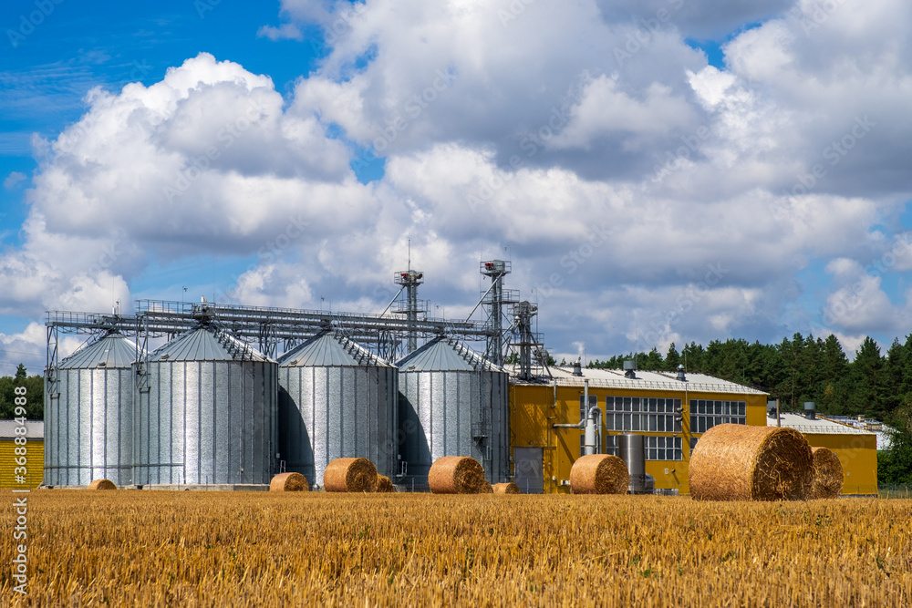 Modern agro manufacturing plant with metal silos for processing drying cleaning and storage of agricultural products, flour, cereals and grain. Granary elevator. Modern agro manufacturing plant with metal silos for processing drying cleaning and storage of agricultural products, flour, cereals and grain. Granary elevator.