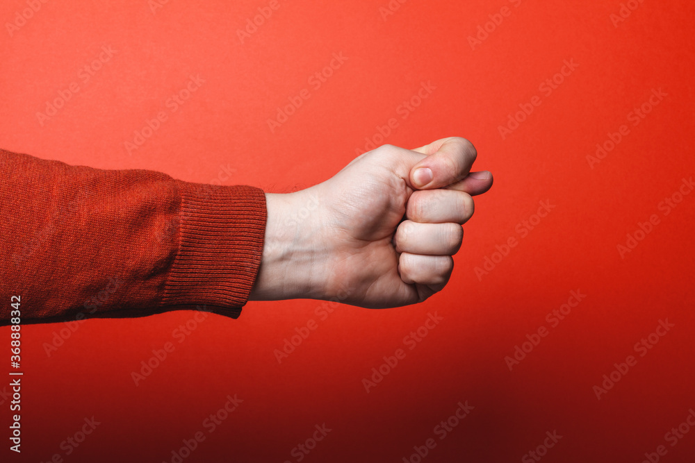 Man hand shows fig sign on red background. Man hand shows fig sign on red background.