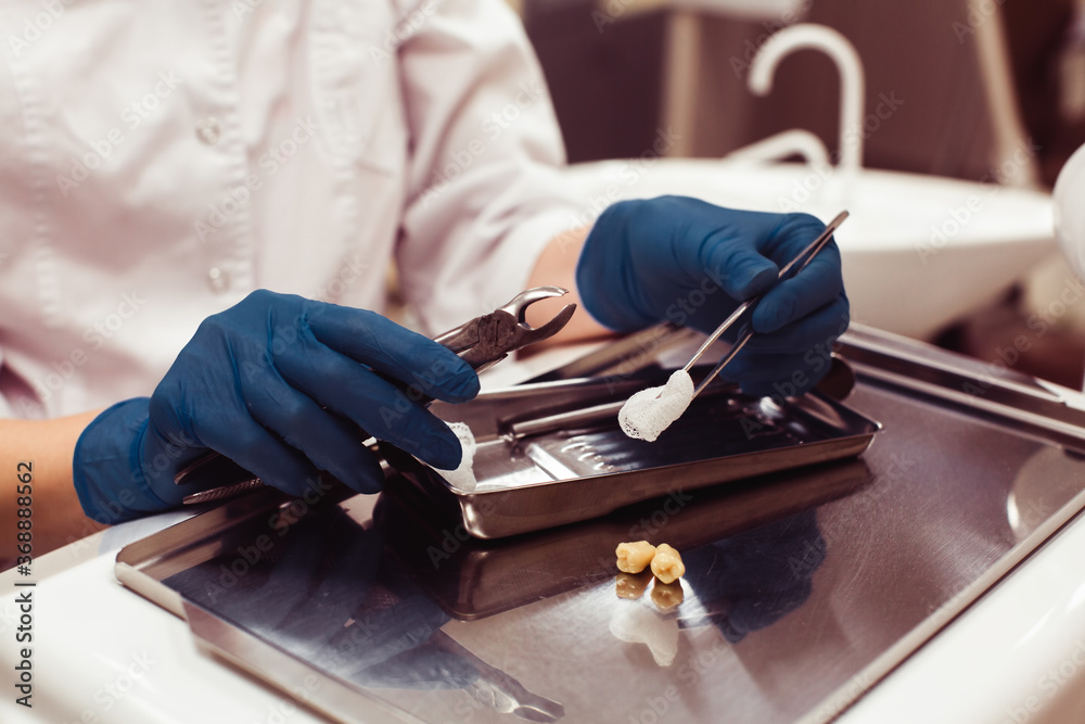 dentist-hands-holding-dental-tools-and-teeth-over-medical-office