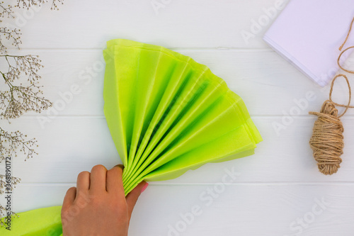 Valokuva Step by step tutorial on making a light green fluffy pom-pom from tissue paper