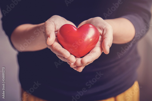 Woman holding red heart, health insurance, donation, happy charity volunteer concept, world mental health day, world heart day photo