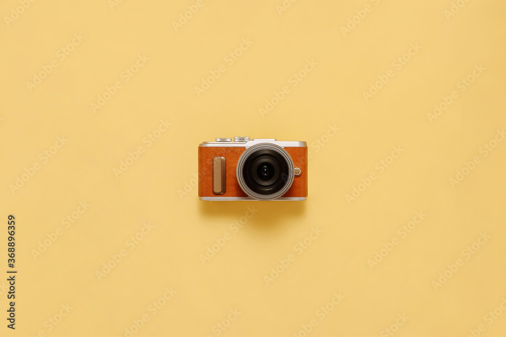 Fototapeta premium Photo camera on yellow background with drop shadow flat lay. Travel or vacation concept top view composition.