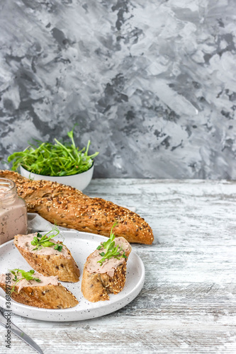 Turkey liver pate on a whole grain baguette with pea sprouts. A simple and comfortable snack 