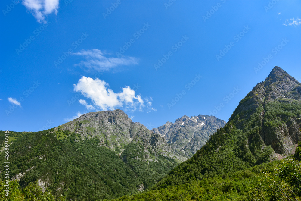 View of the beautiful countryside of North Ossetia. Sunny day. Beautiful summer landscape in the mountains. Grassy fields and hills. Rural landscapes