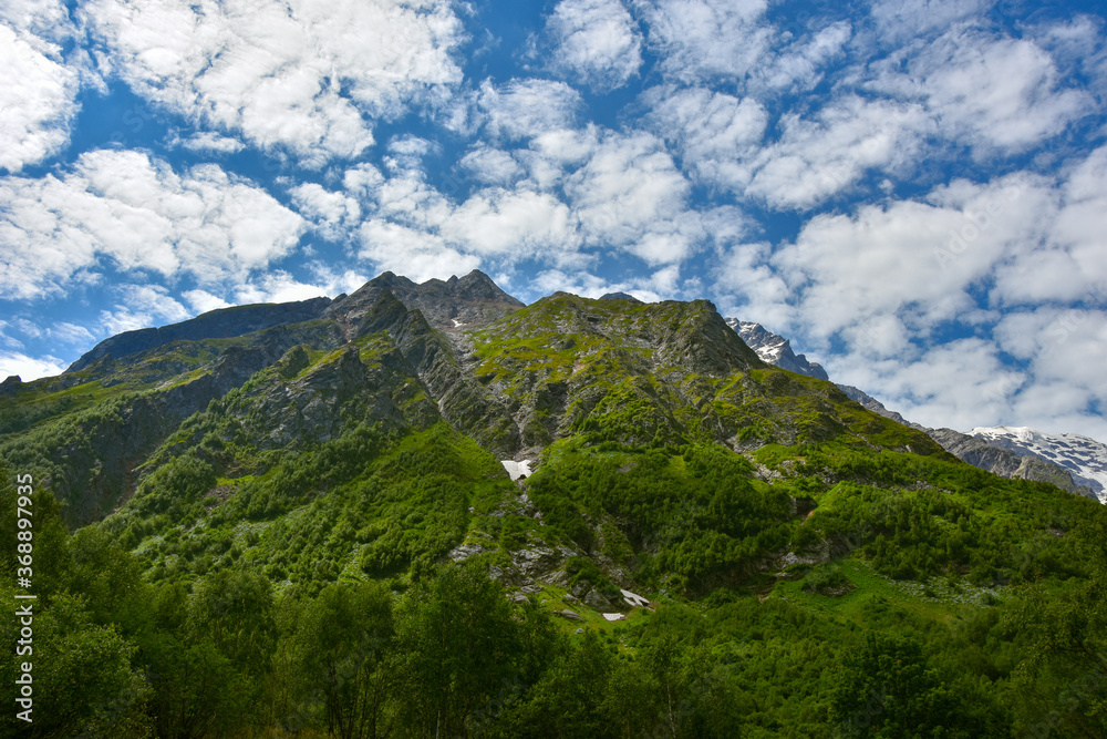 View of the beautiful countryside of North Ossetia. Sunny day. Beautiful summer landscape in the mountains. Grassy fields and hills. Rural landscapes