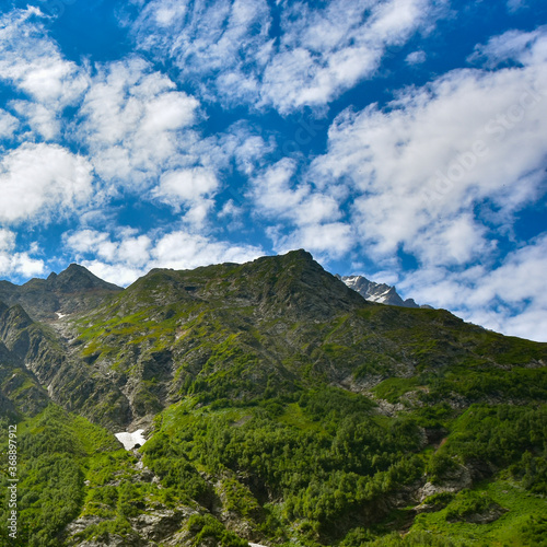 View of the beautiful countryside of North Ossetia. Sunny day. Beautiful summer landscape in the mountains. Grassy fields and hills. Rural landscapes