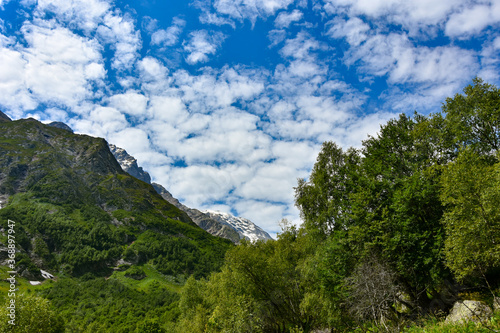 View of the beautiful countryside of North Ossetia. Sunny day. Beautiful summer landscape in the mountains. Grassy fields and hills. Rural landscapes