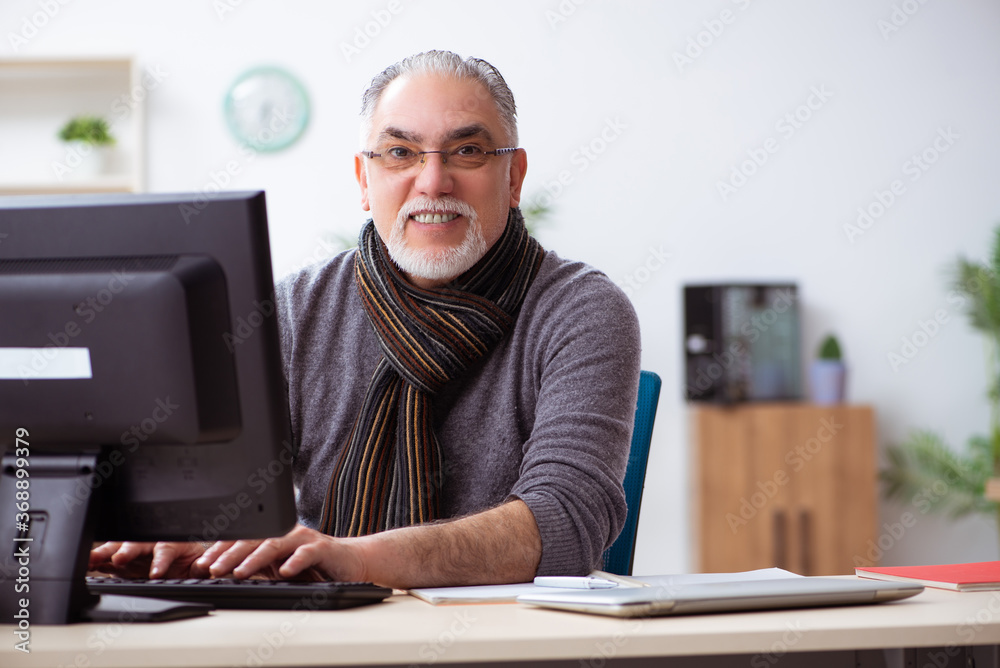 Old male employee working from house during pandemic