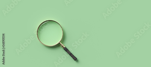 Photography magnification glass on the left on empty green background