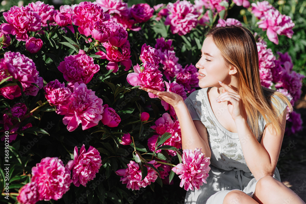 Floral concept. Shallow depth of field.Pink peony flower field.Girl and peonies