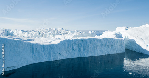 Global Warming and Climate Change concept. Icebergs from melting glacier in icefjord - Icefjord in Ilulissat, Greenland. Aerial drone photo of arctic nature ice landscape. photo