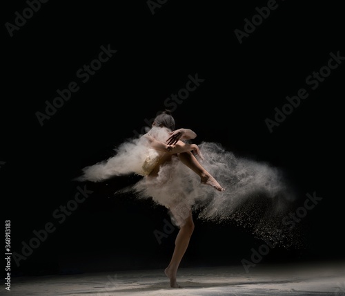 Graceful lady in body dance in cloud of dust
