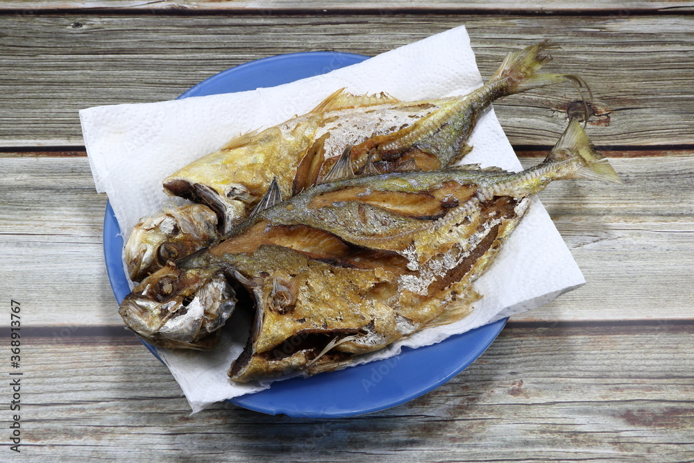Traditional Deep fried king mackerel fish on the plastic plate. Famous