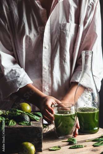 Woman takes a glass of smoothie into a glass, detox, wholesome food, vegan, eco. Body cleansing