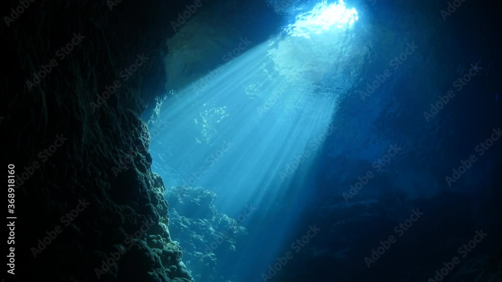 sun rays sun beams and sun shine underwater in cave beautiful light scenery in ocean scuba divers to see