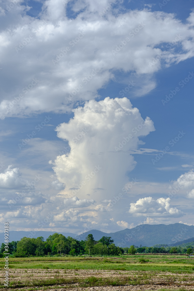 The white clouds have a strange shape and country side.Cloudy and blue sky