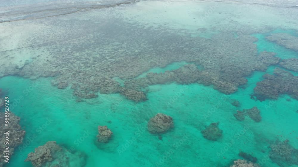 Sideways aerial of stunning coral reef ecosystem with clear turquoise water Sideways aerial of stunning coral reef ecosystem with clear turquoise water