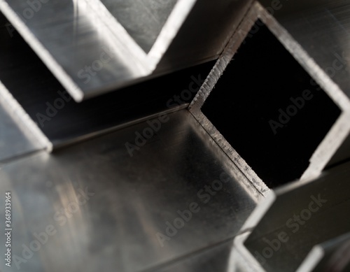 Abstract stack of aluminium profiles close up, industrial background macro