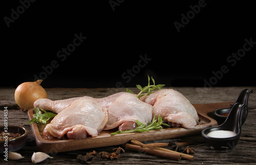 fresh chicken meat with rosemary and spices on wooden board. photo