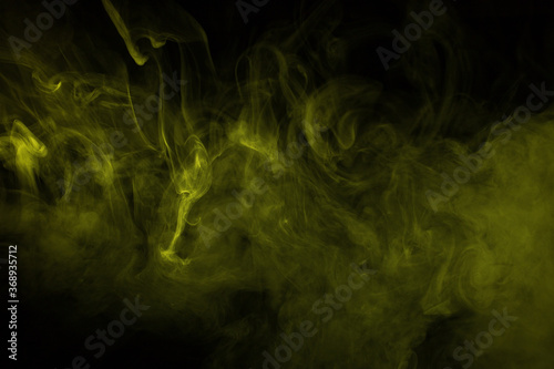 Colorful smoke close-up on a black background. Yellow cloud of smoke. © vfhnb12