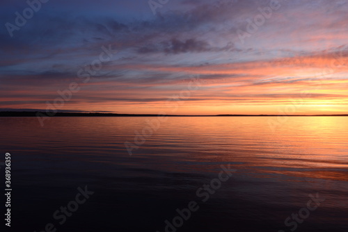 Sunset in the clouds blue sky over calm water © yarvin13